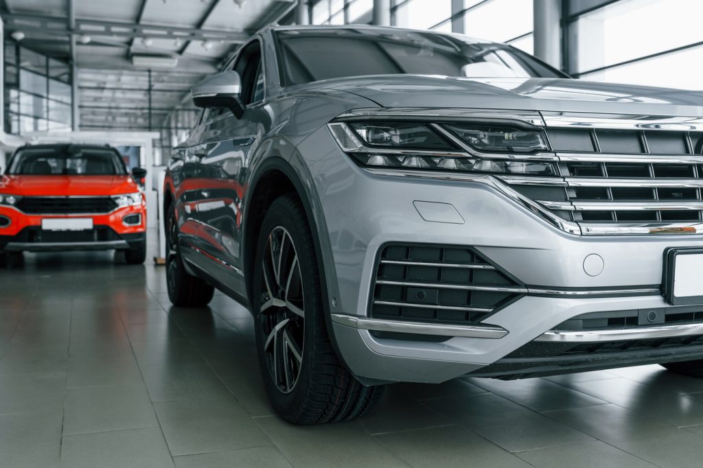 front view of modern new silver colored car andRabljena vozila | Preverjena ponudba | Avto Wikra red one behind
