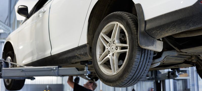 repair of cars, chassis, automatic transmission and engine in an auto repair shop or garage. the car is lifted on a lift.